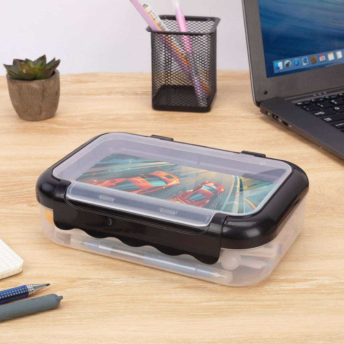 Clear plastic pencil storage box with black lid and car-themed print, two compartments.