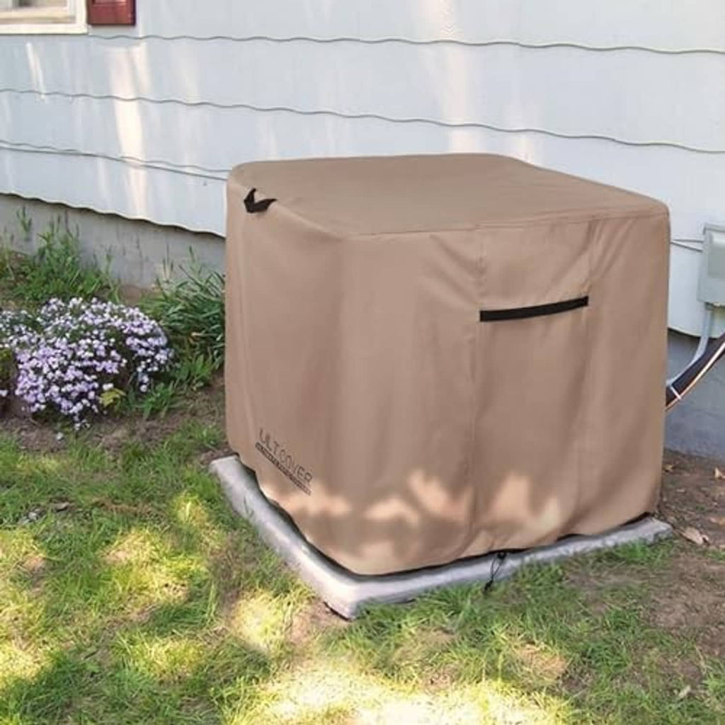 Brown square AC cover secured over an outdoor unit with fastening cords