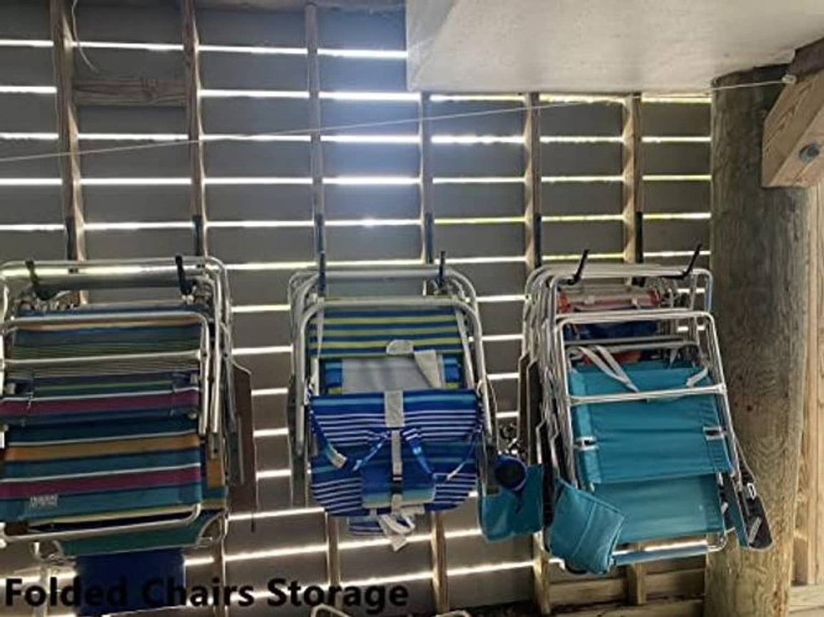 Wall-mounted black ladder hooks holding folded items on a metal rail
