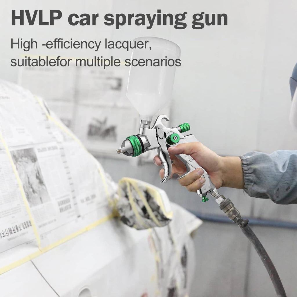Hand using HVLP spray gun to apply paint to a car body panel