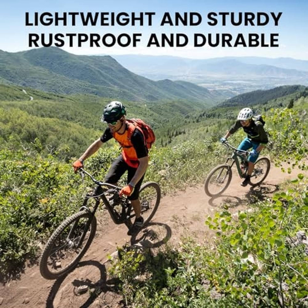 Two mountain bikes riding on a dirt trail with green hills in the background