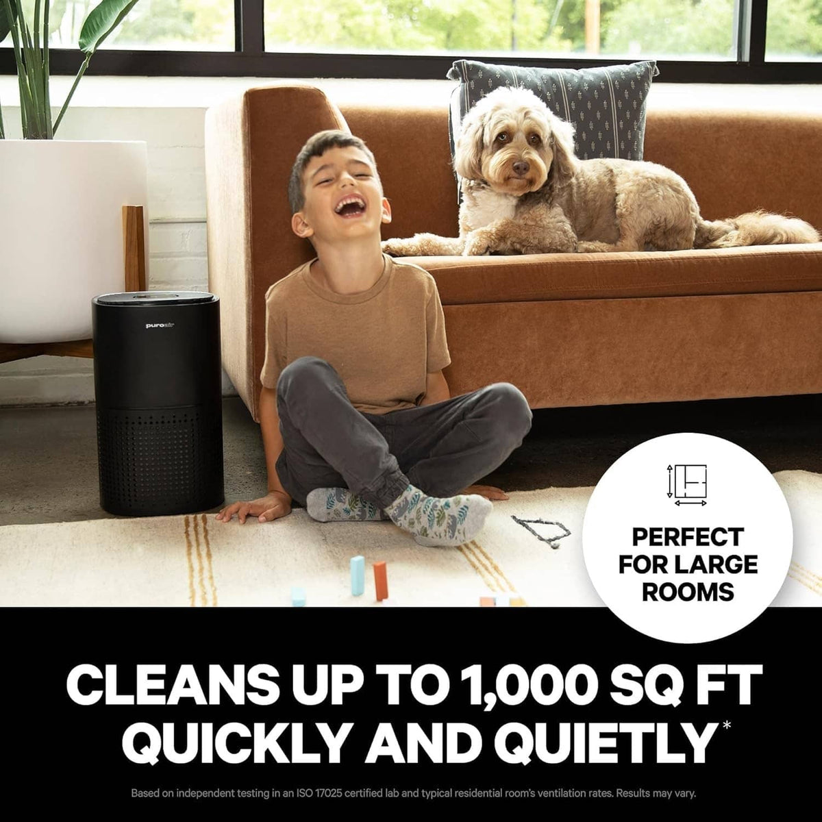Black air purifier tower on floor near couch, visible front grille