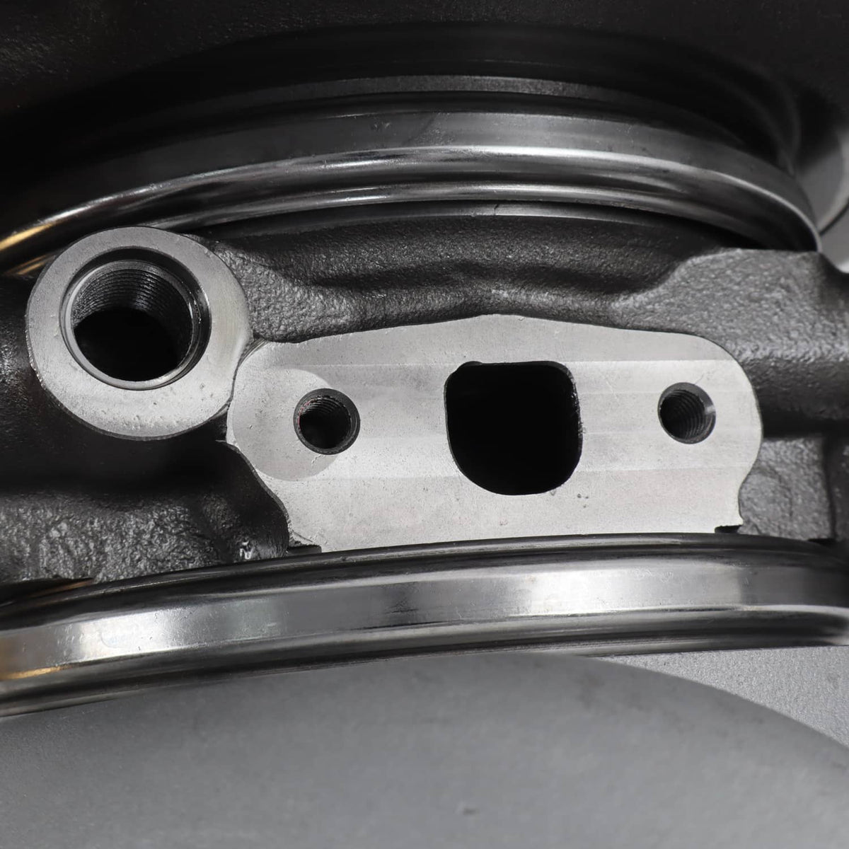 Diesel turbocharger close-up of actuator bracket with capped ports and mounting holes