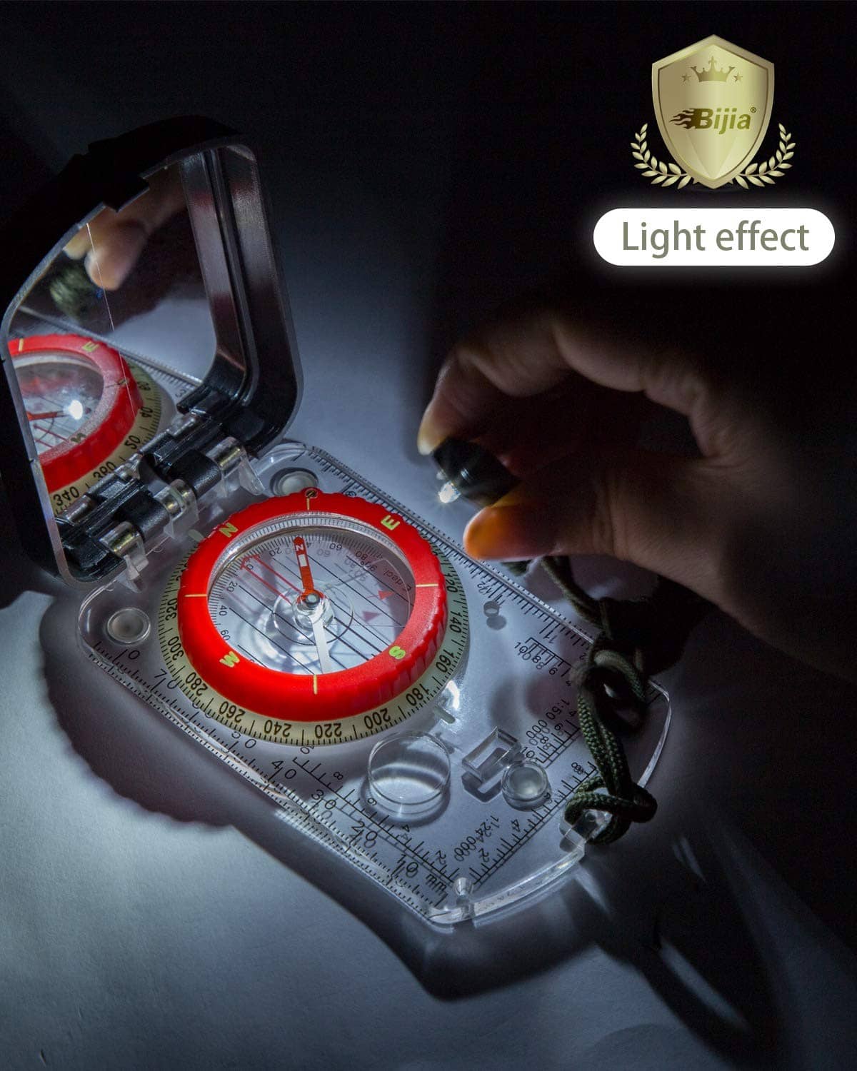 Orienteering compass with red dial and sighting mirror in illuminated low-light view