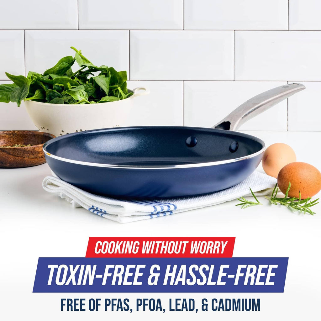 Blue nonstick frying pan skillet with speckled interior, silver handle, and egg on stove setup