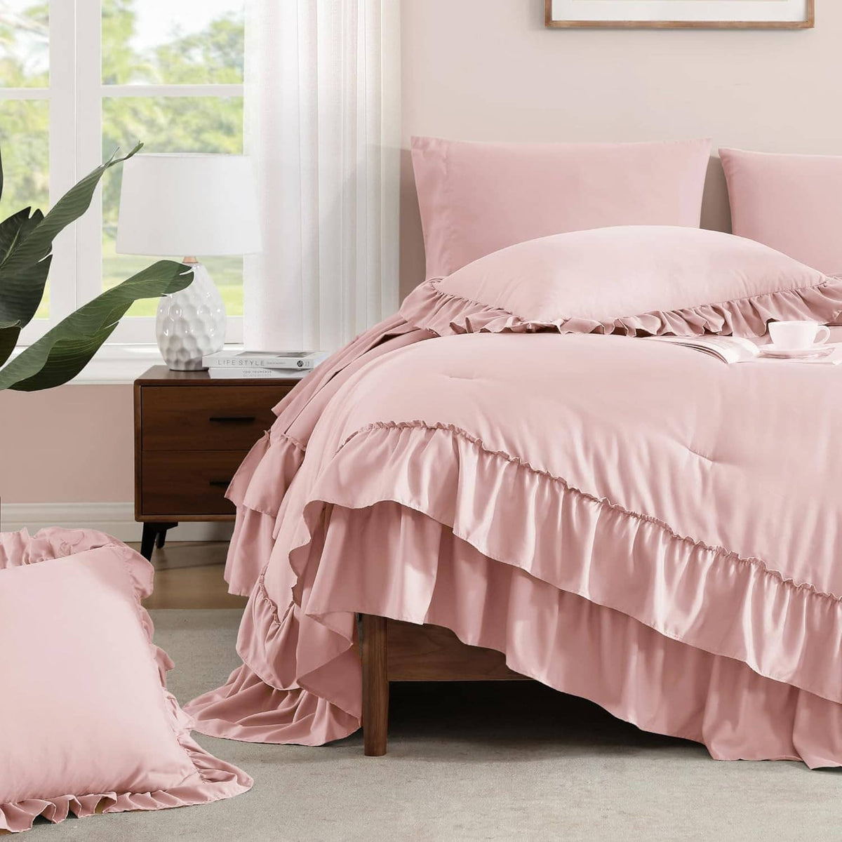 Blush pink comforter skirt with ruffle hem and matching pillow shams on bed