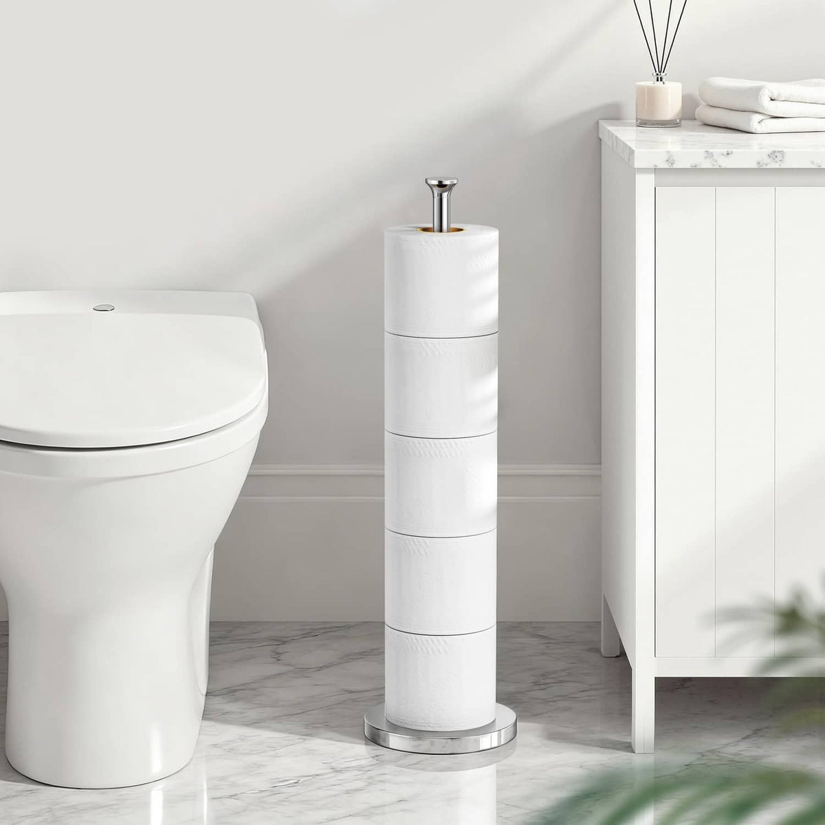 Freestanding toilet paper holder stand holding stacked rolls, chrome base
