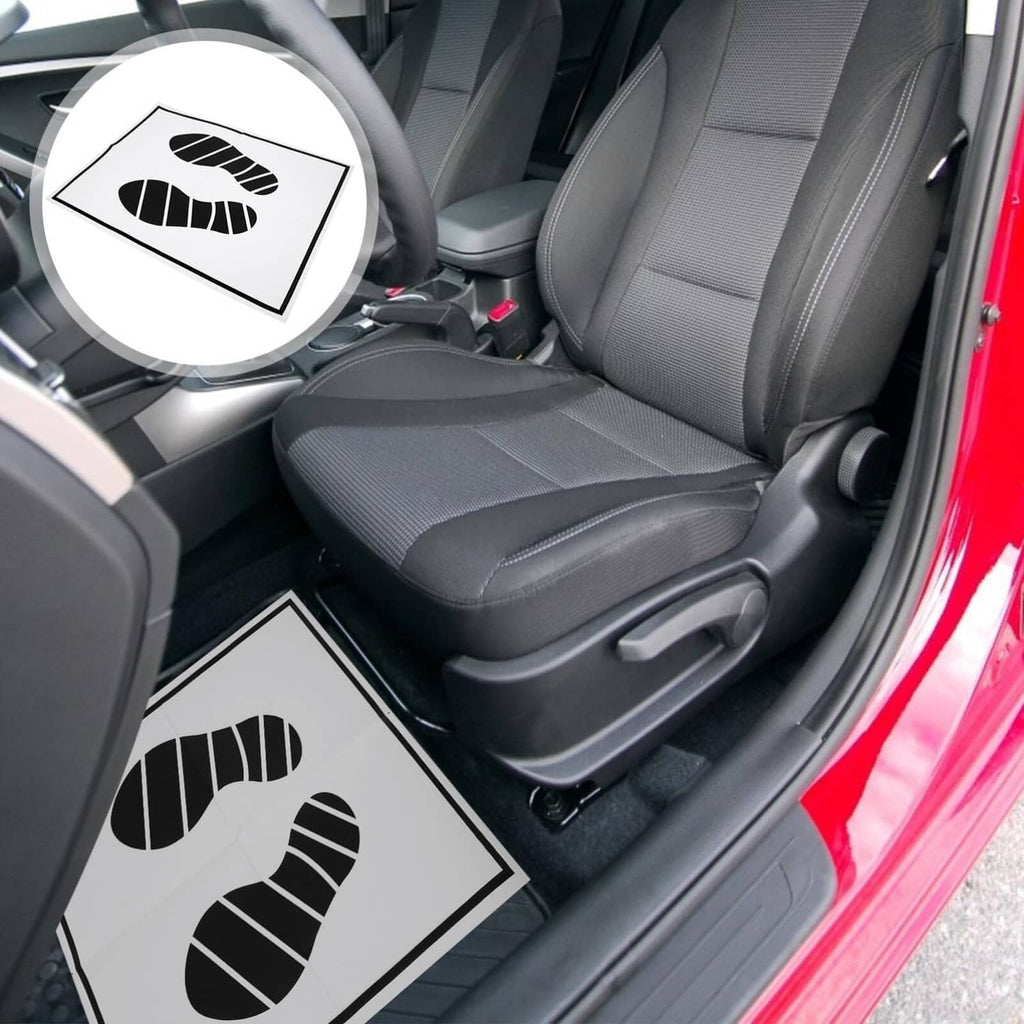 Disposable paper foot mat with black footprint print on car driver seat floor area