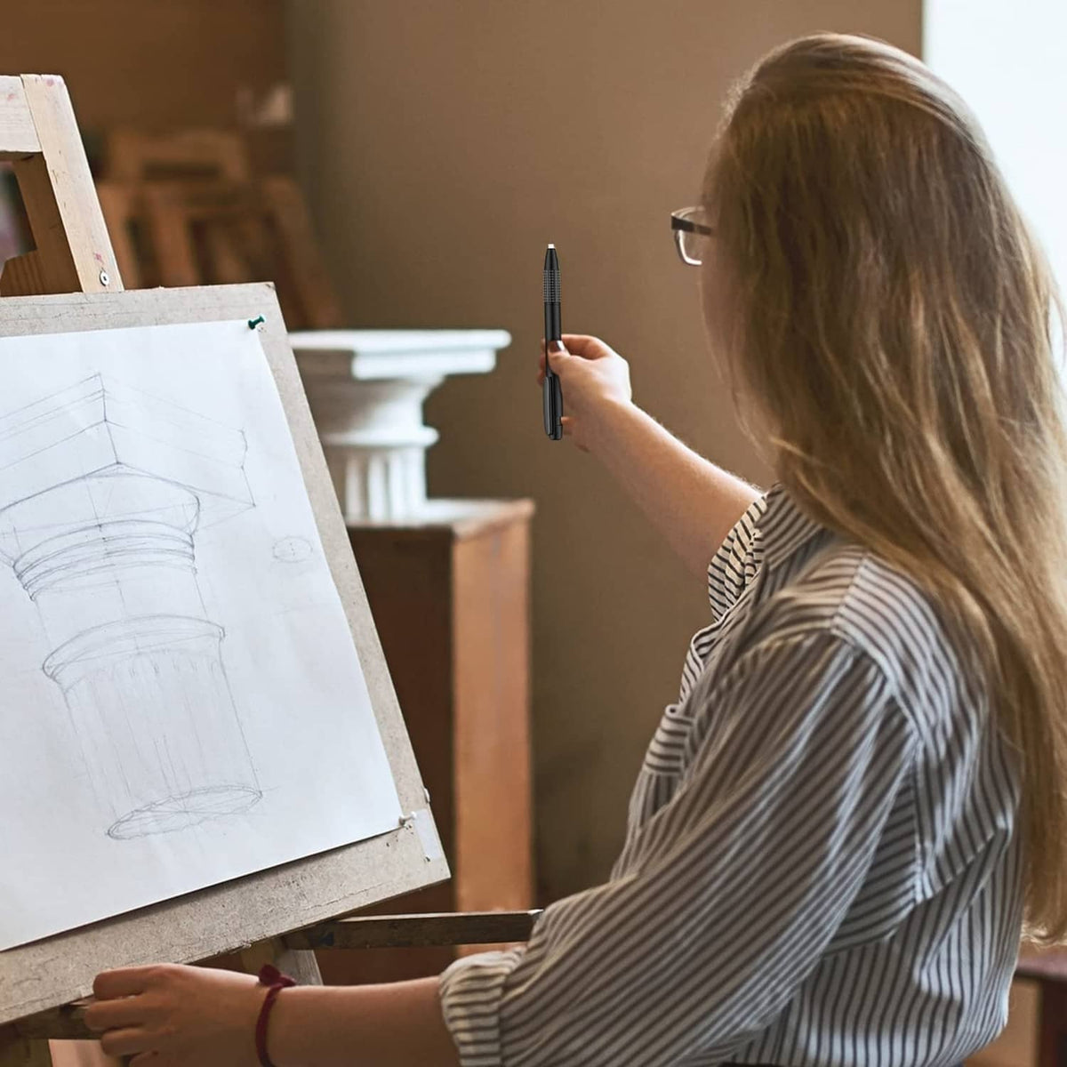 Retractable eraser mechanical pen held in hand while drawing on canvas