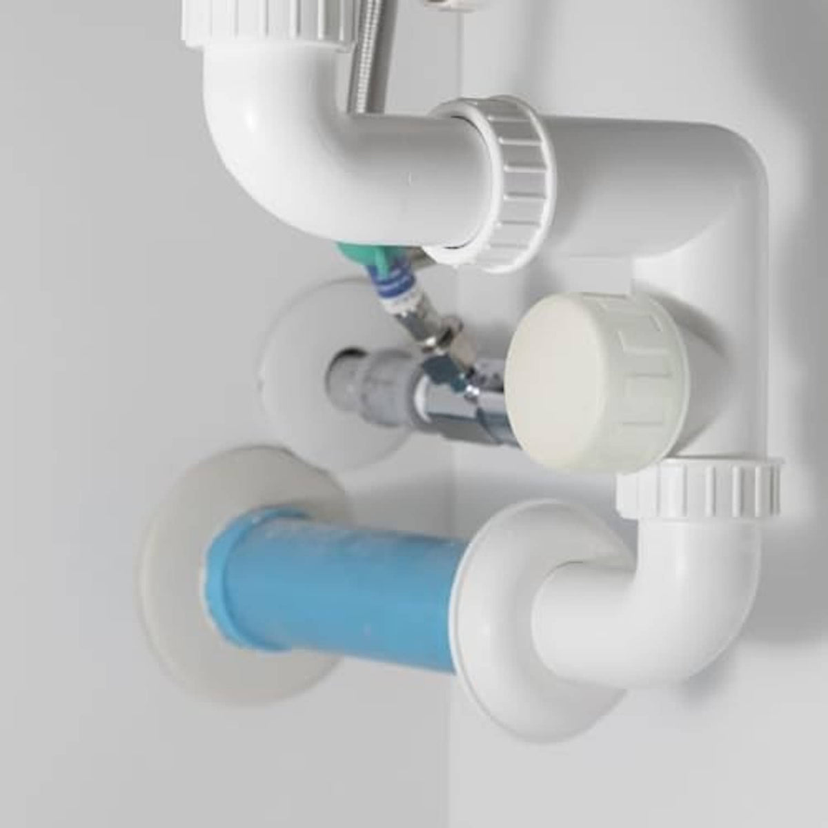 PVC sprinkler pipe cap, white cap attached to sprinkler line near blue tubing