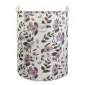 Collapsible laundry basket with white base and purple floral leaf print, open top.