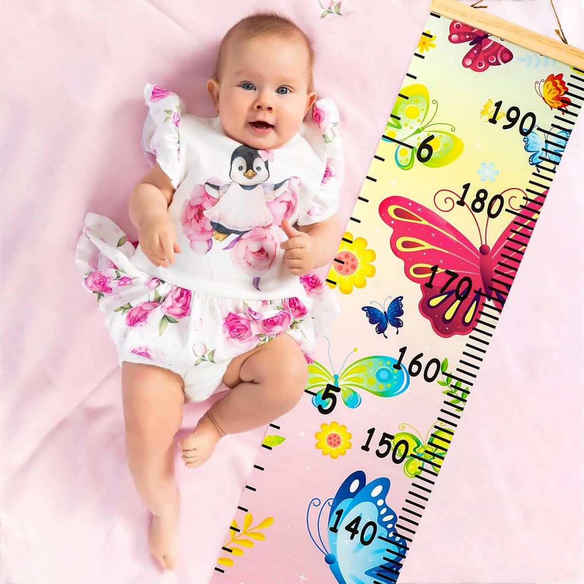 Kids growth chart canvas with butterfly height scale next to baby on pink blanket