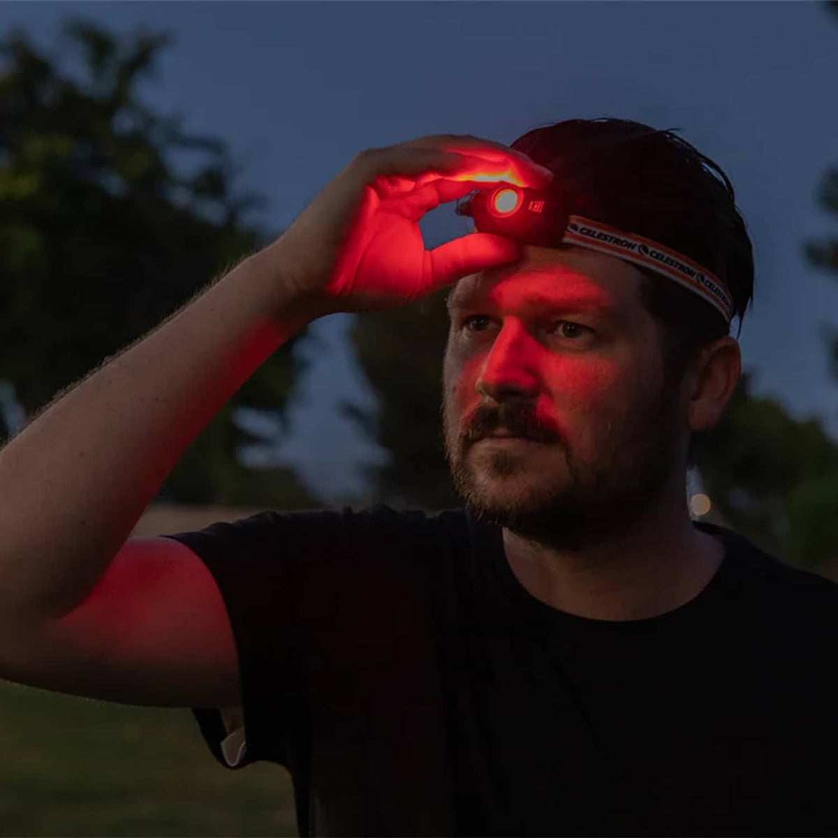 Night vision headlamp on person’s head with red LED glowing