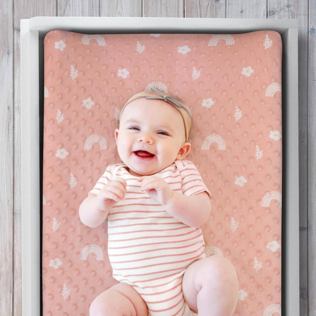 Peach-pink minky changing pad cover with textured dots and small flower accents