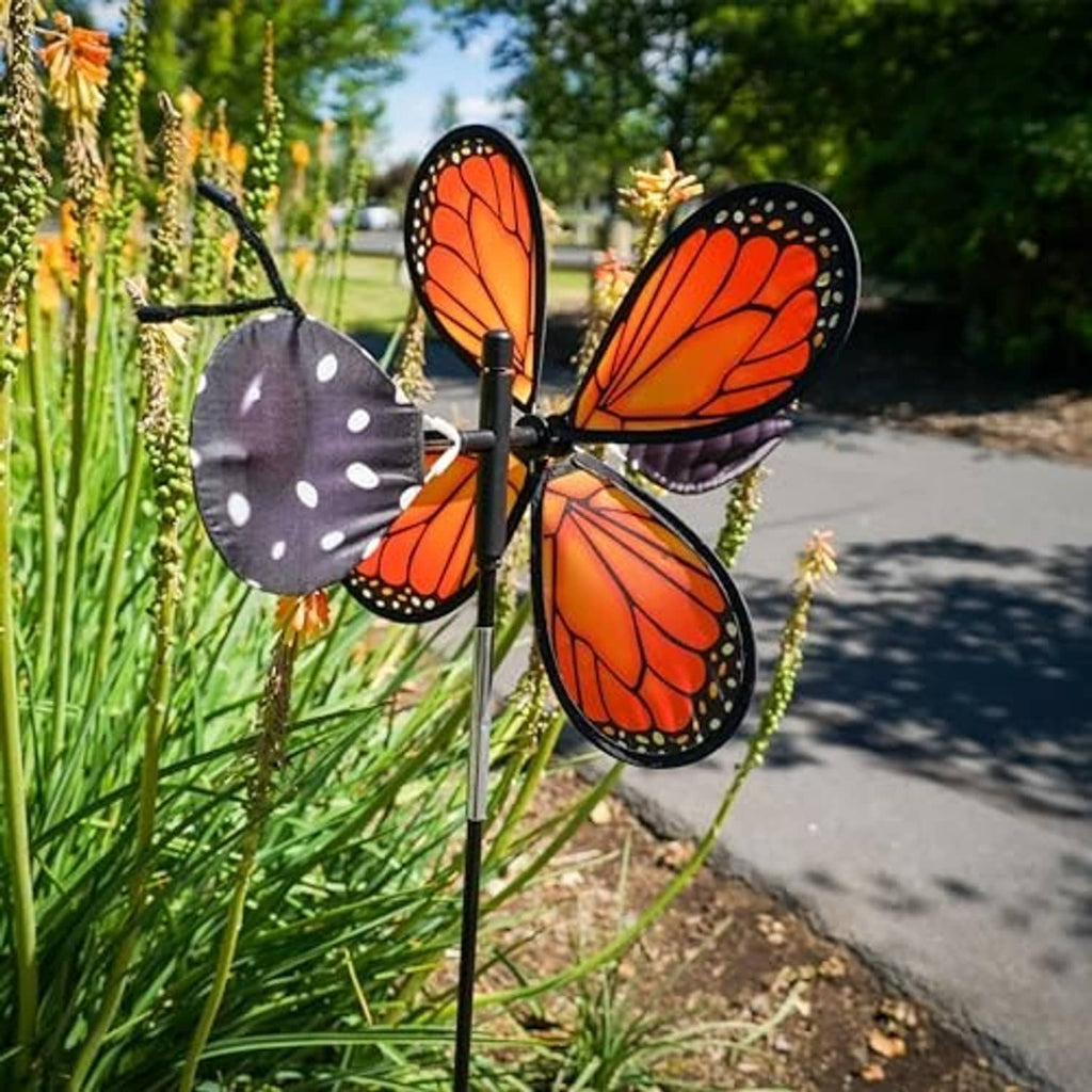 Monarch butterfly wind spinner close-up on a black pole with orange-and-black wings