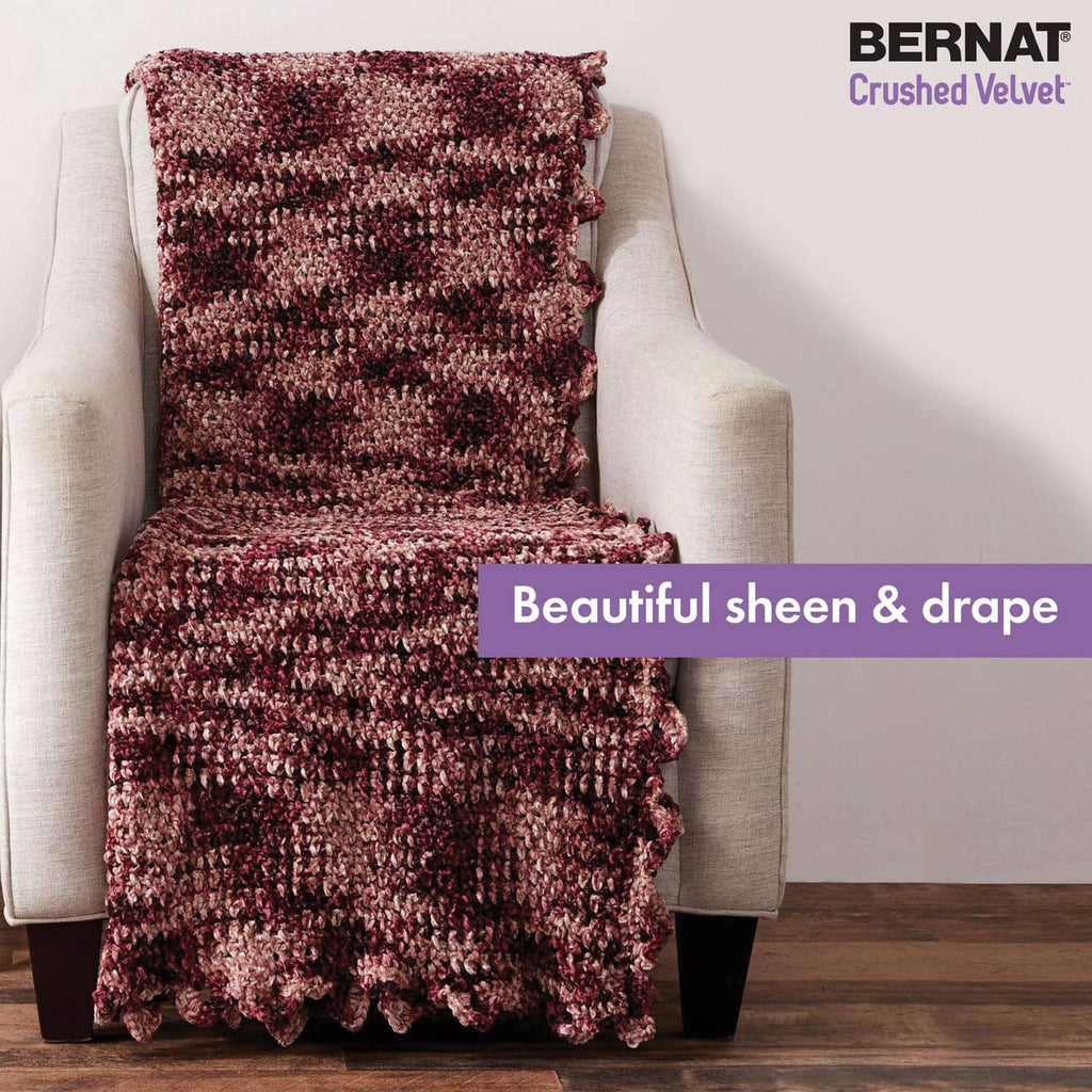 Maroon and pink textured knit throw blanket draped over an armchair.