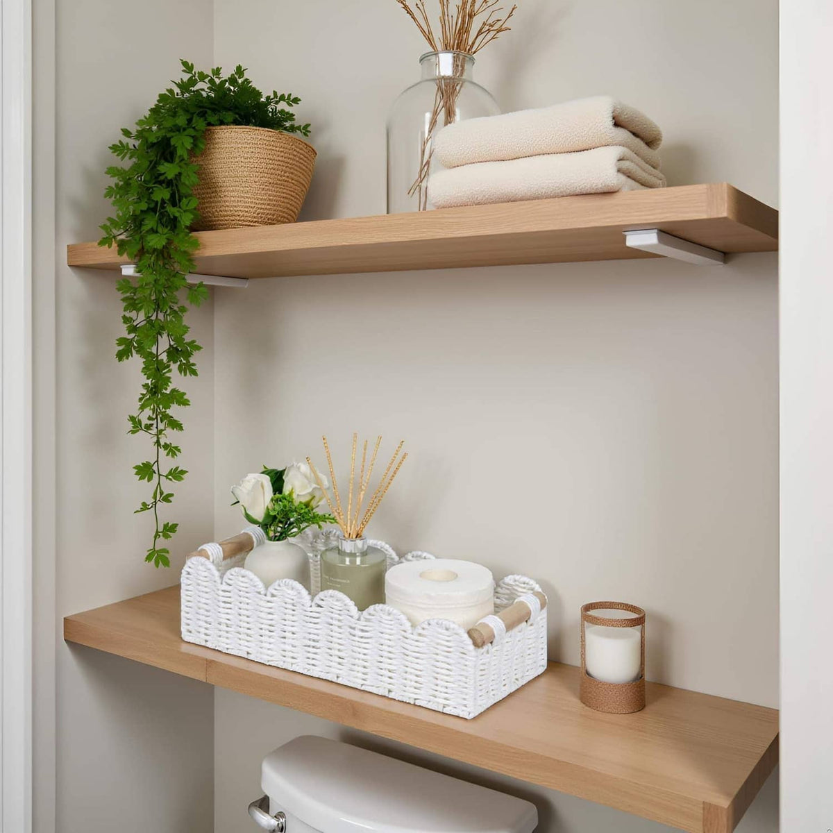 White woven toilet paper storage basket with scalloped rim and wooden handle ends