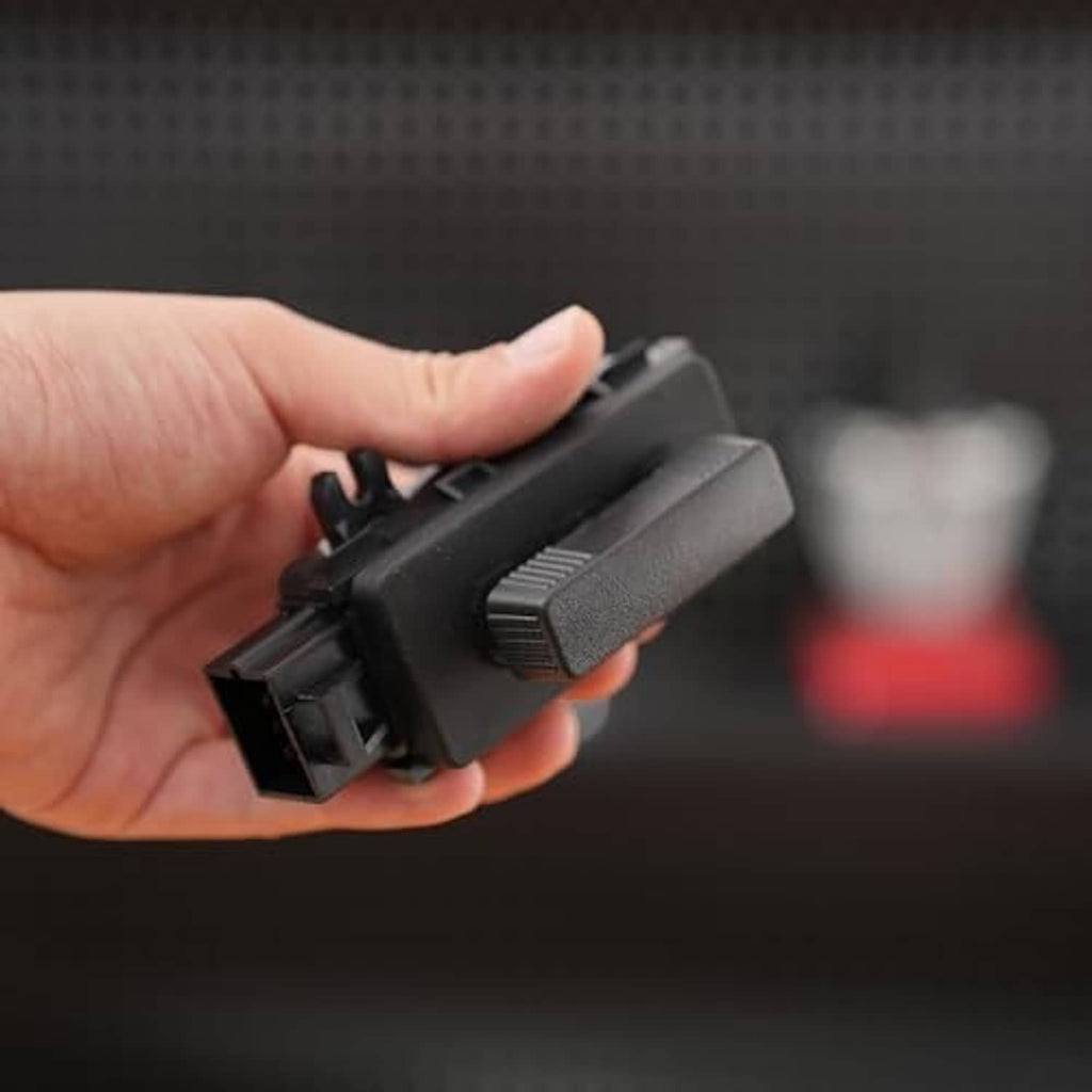Black power seat switch held in hand, textured control lever on top