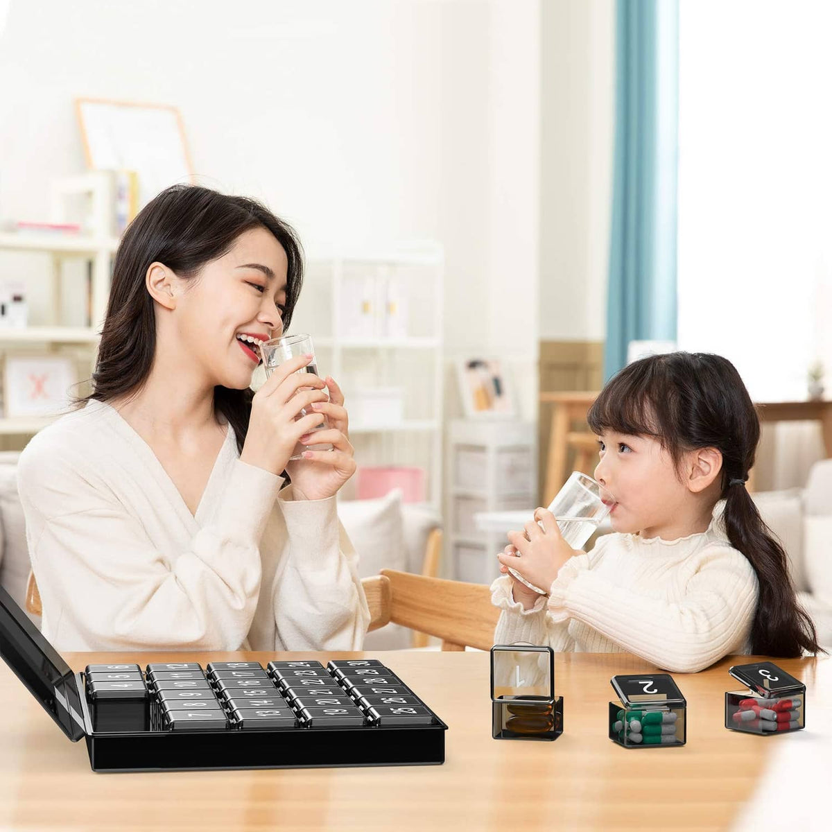 Black monthly pill organizer case on table with hinged lid and numbered compartments