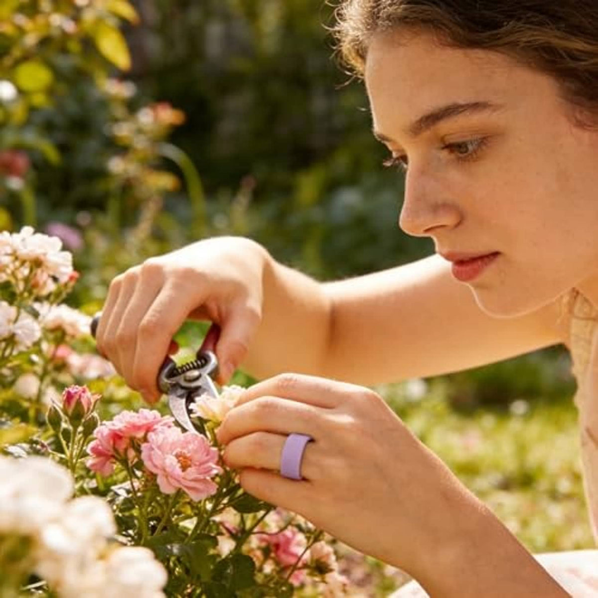 Dark silicone Oura ring cover on finger during outdoor gardening