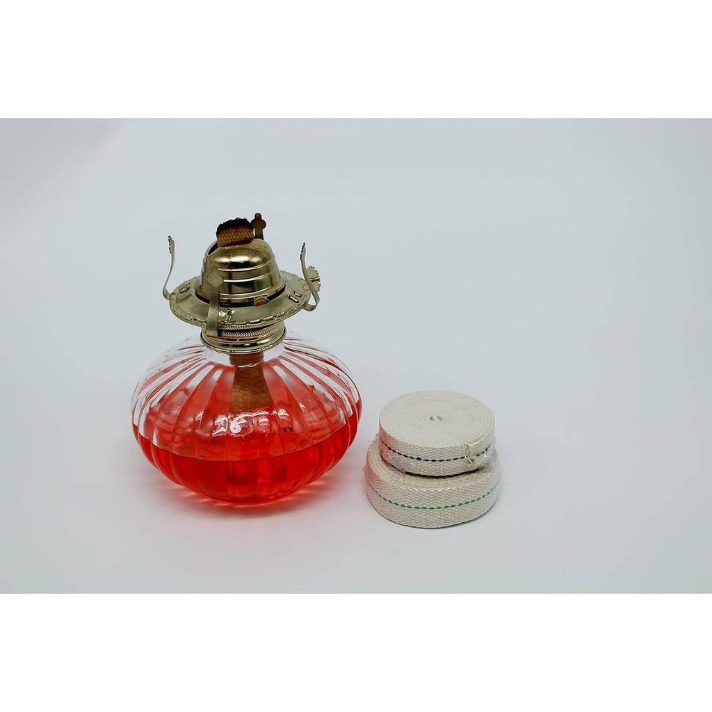 Cotton oil lamp wick roll with blue stitching shown with red oil lamp globe