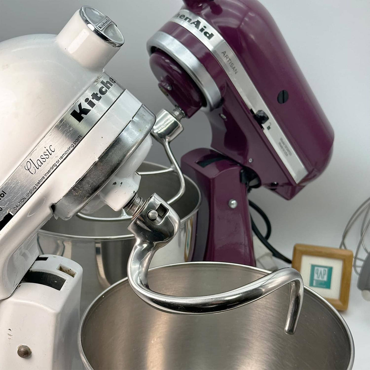 Close-up of spiral dough hook over metal mixing bowl, shiny silver