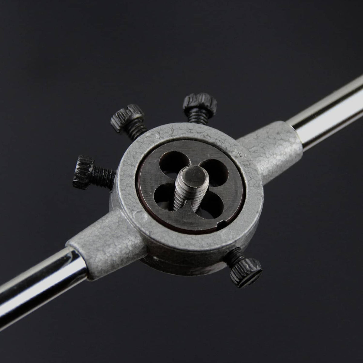 Round right-hand thread die installed in a threading tool, visible cutting teeth