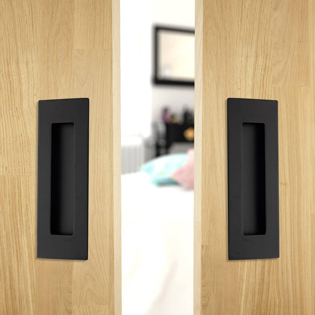 Matte black recessed finger flush pull handle mounted on a wooden door