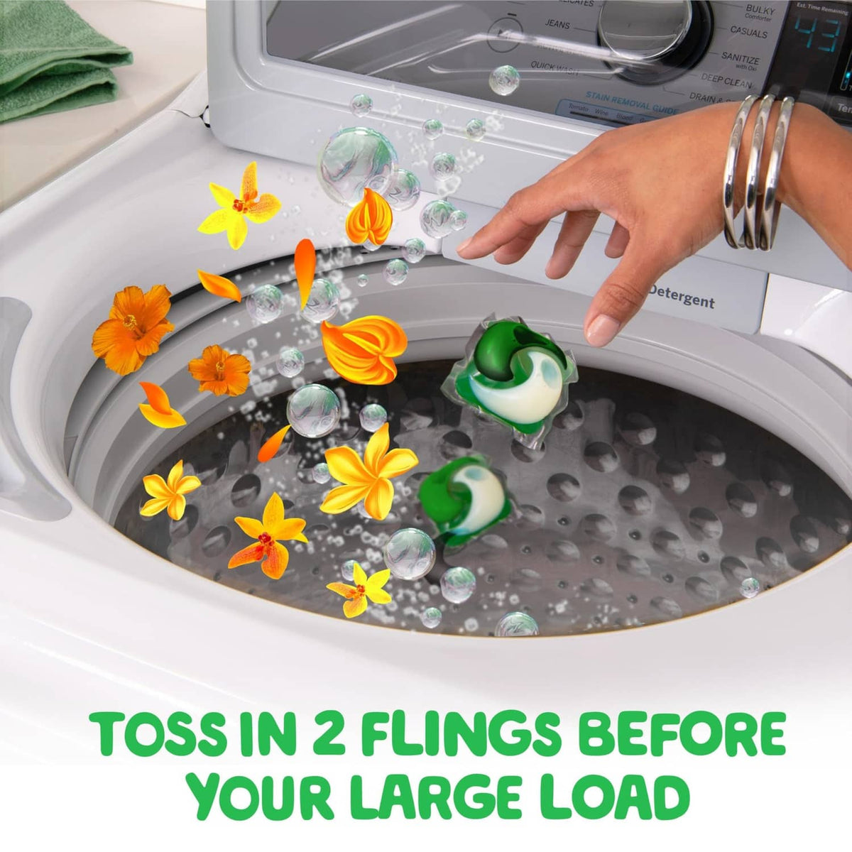 Laundry detergent pacs in washing machine drum, hand dropping pods before large load