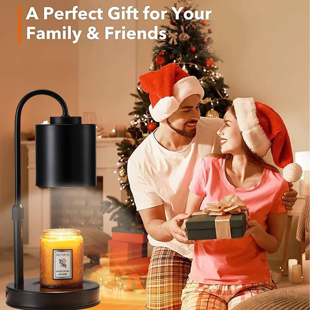 Black candle warmer lamp on table next to a lit jar candle, holiday gift scene