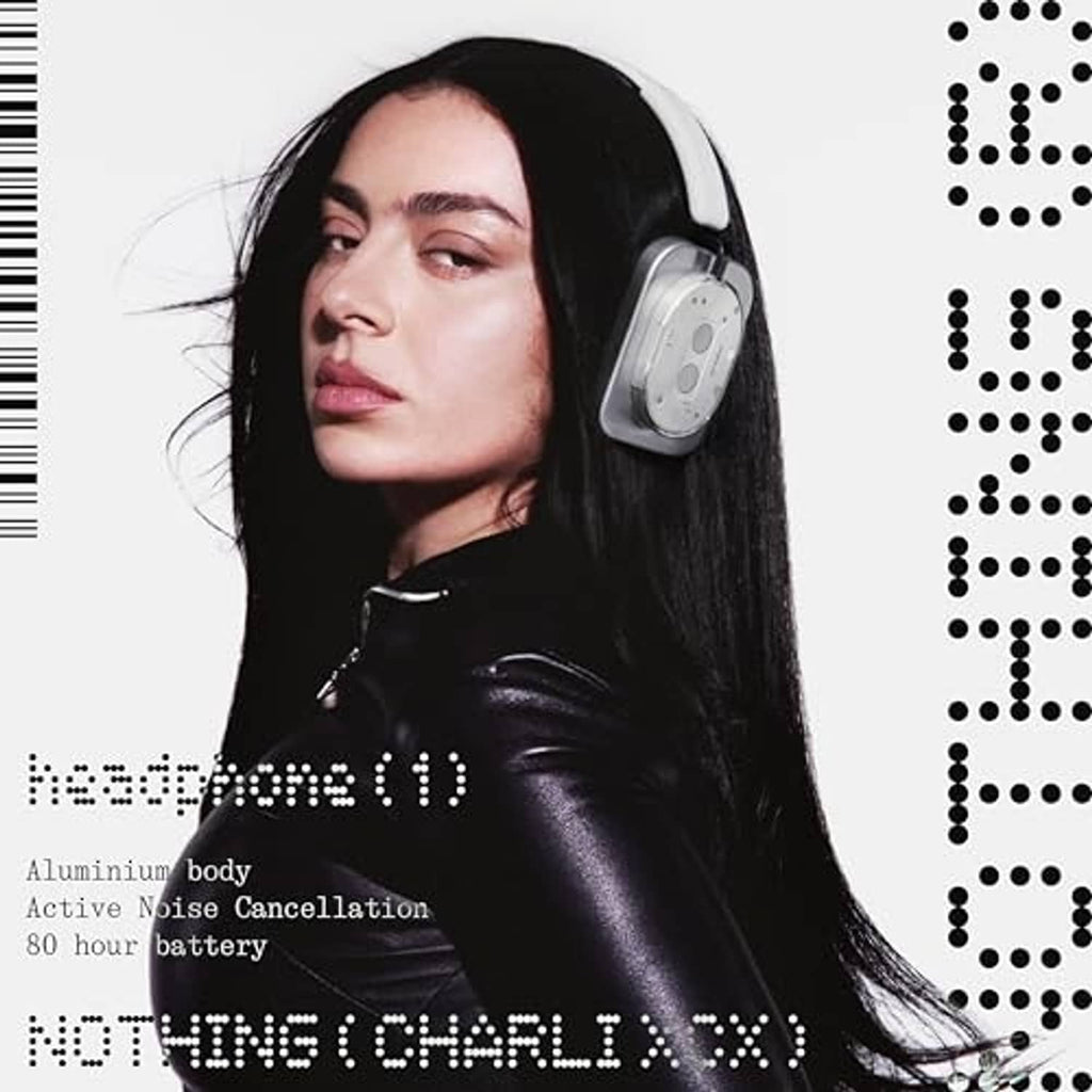Silver over-ear wireless headphones on model, black headband and padded earcups