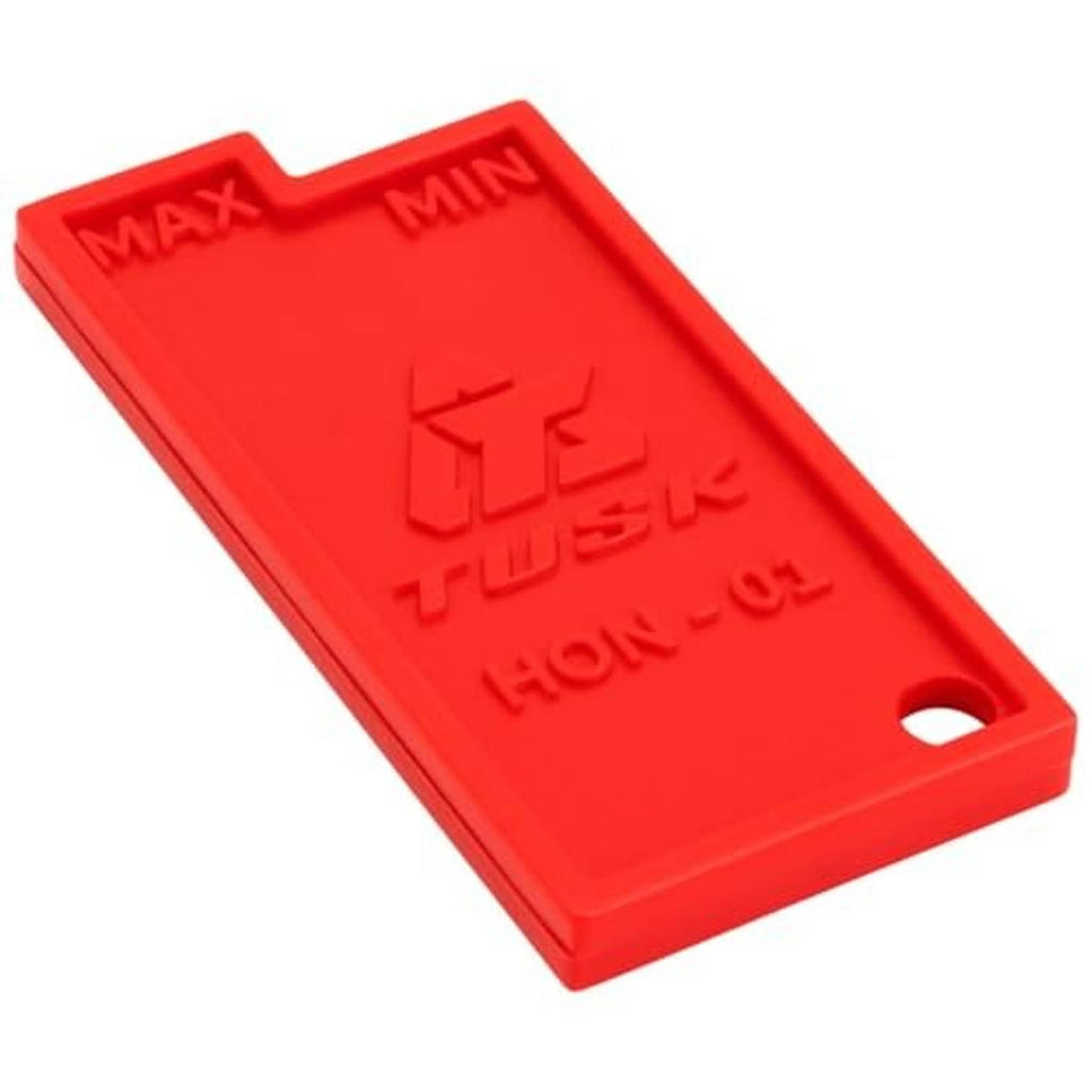 Red chain slack measuring tool showing engraved MAX/MIN guides and side hole
