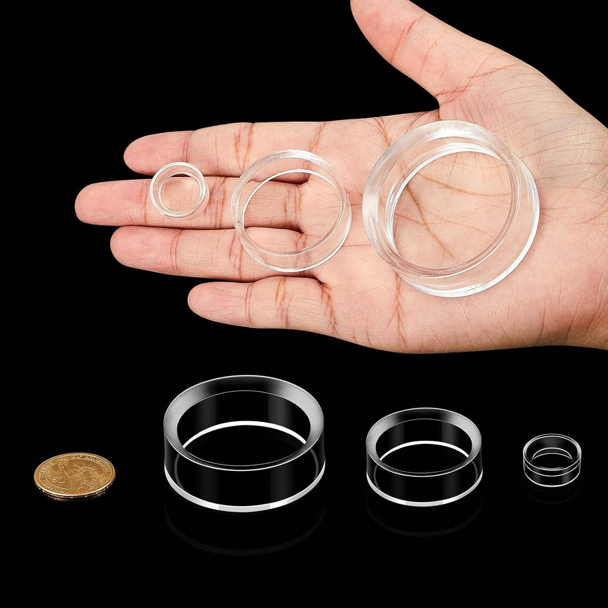 Clear acrylic sphere stands with open ring bases, held in hand with small ring sizes