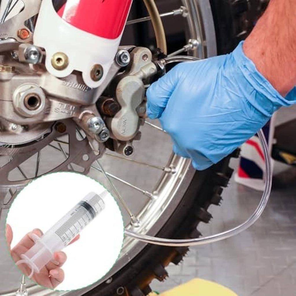 Hydraulic brake line bleeding setup using syringe and clear hose on motorcycle