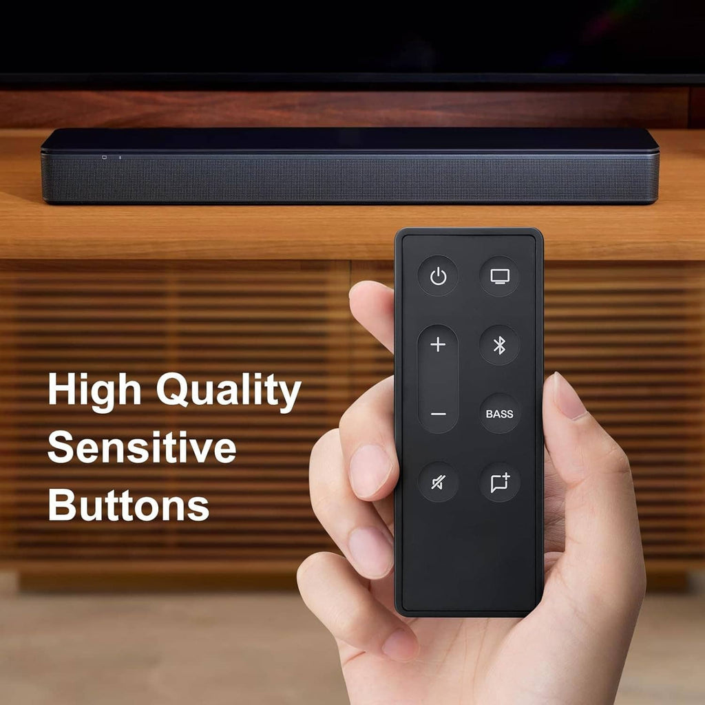 Black remote control held toward a soundbar with a full button layout