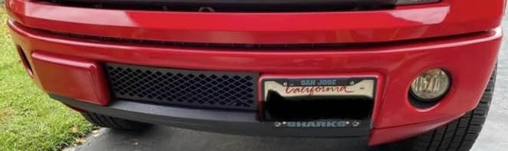 Red truck front with black diamond-mesh bumper grille insert opening