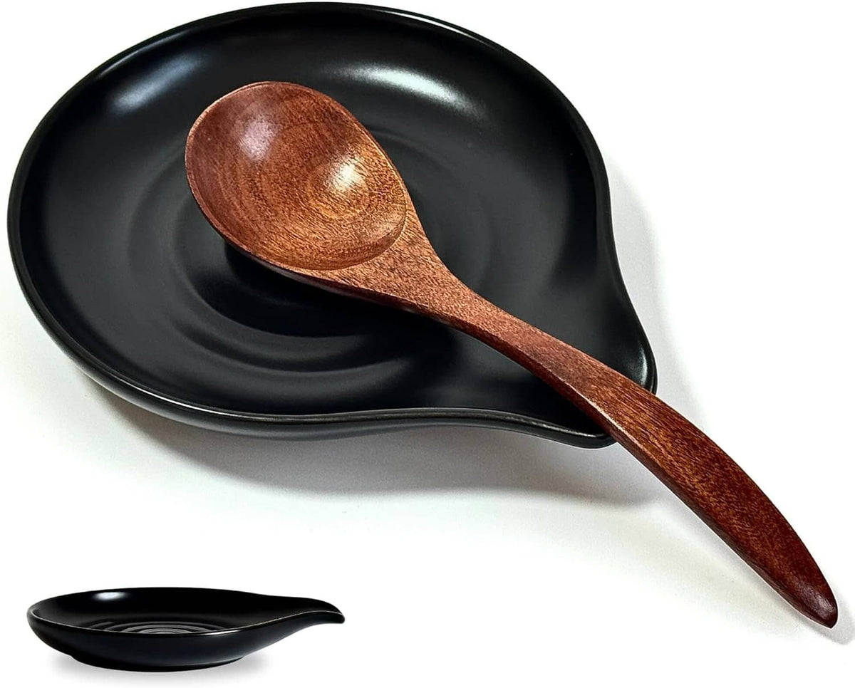 Black ceramic spoon rest with brown wooden spoon and concave leaf-shaped tray