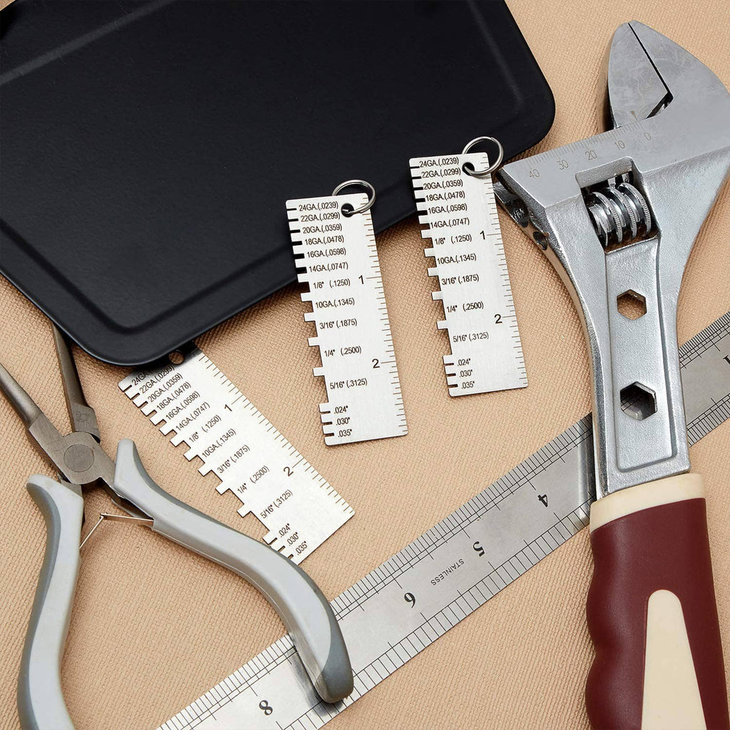 Metal thickness gauge set with multiple etched cards and measuring scale alongside tool