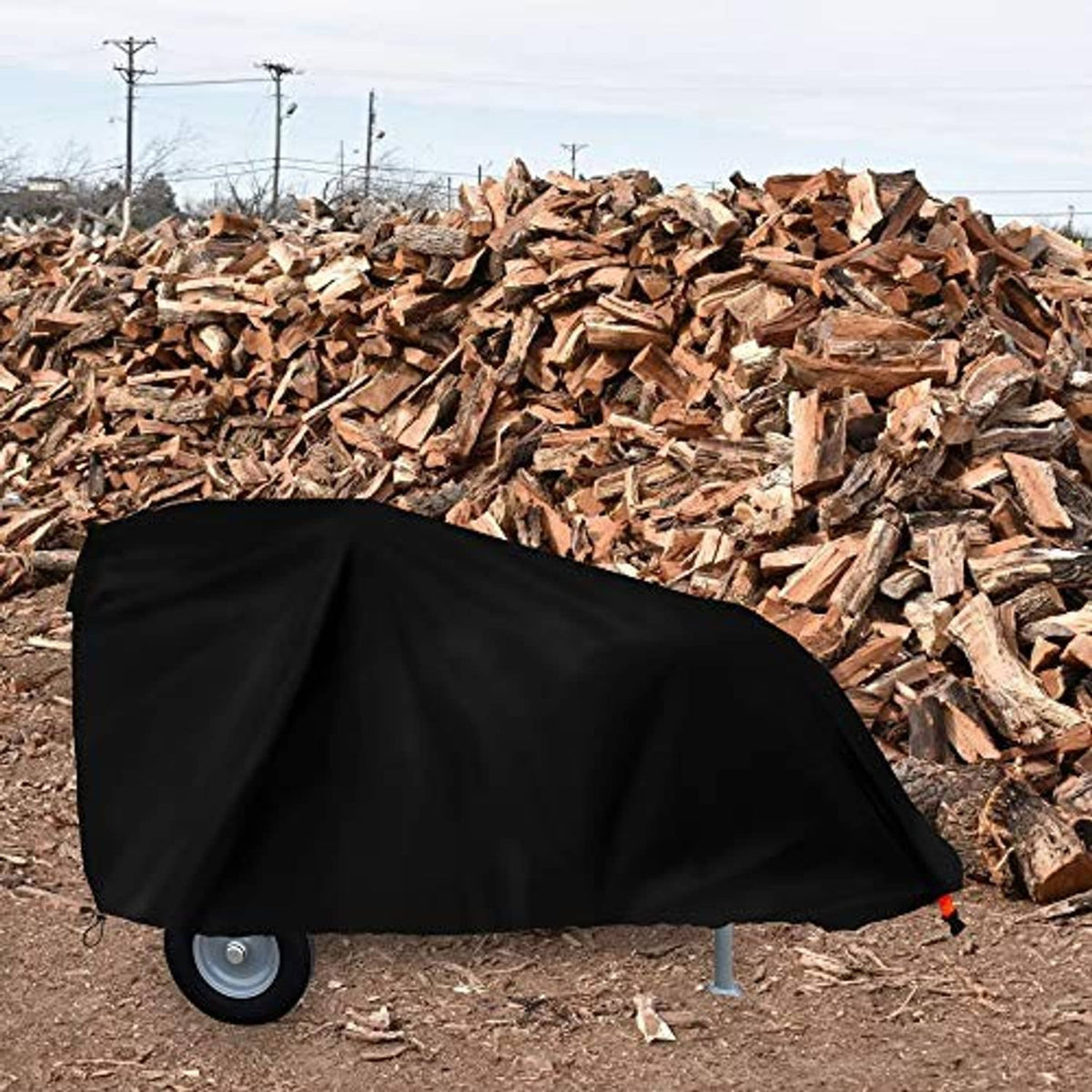 Black log splitter cover over a wheeled log splitter, secured with tie-down straps