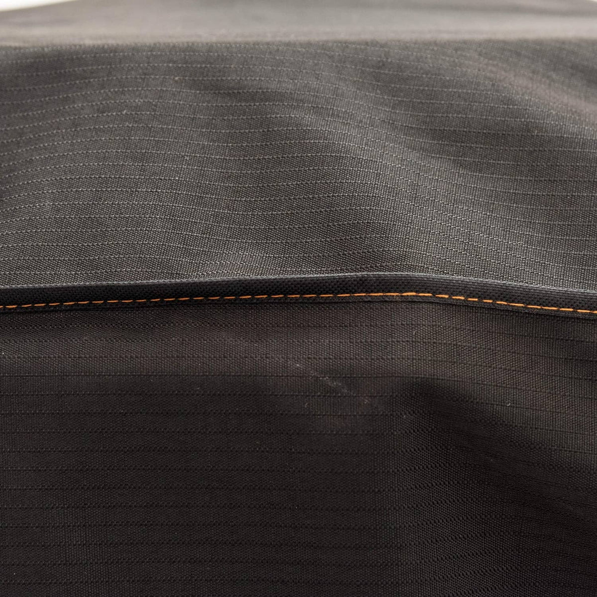 Black smoker cover fabric with orange contrast stitching along top seam