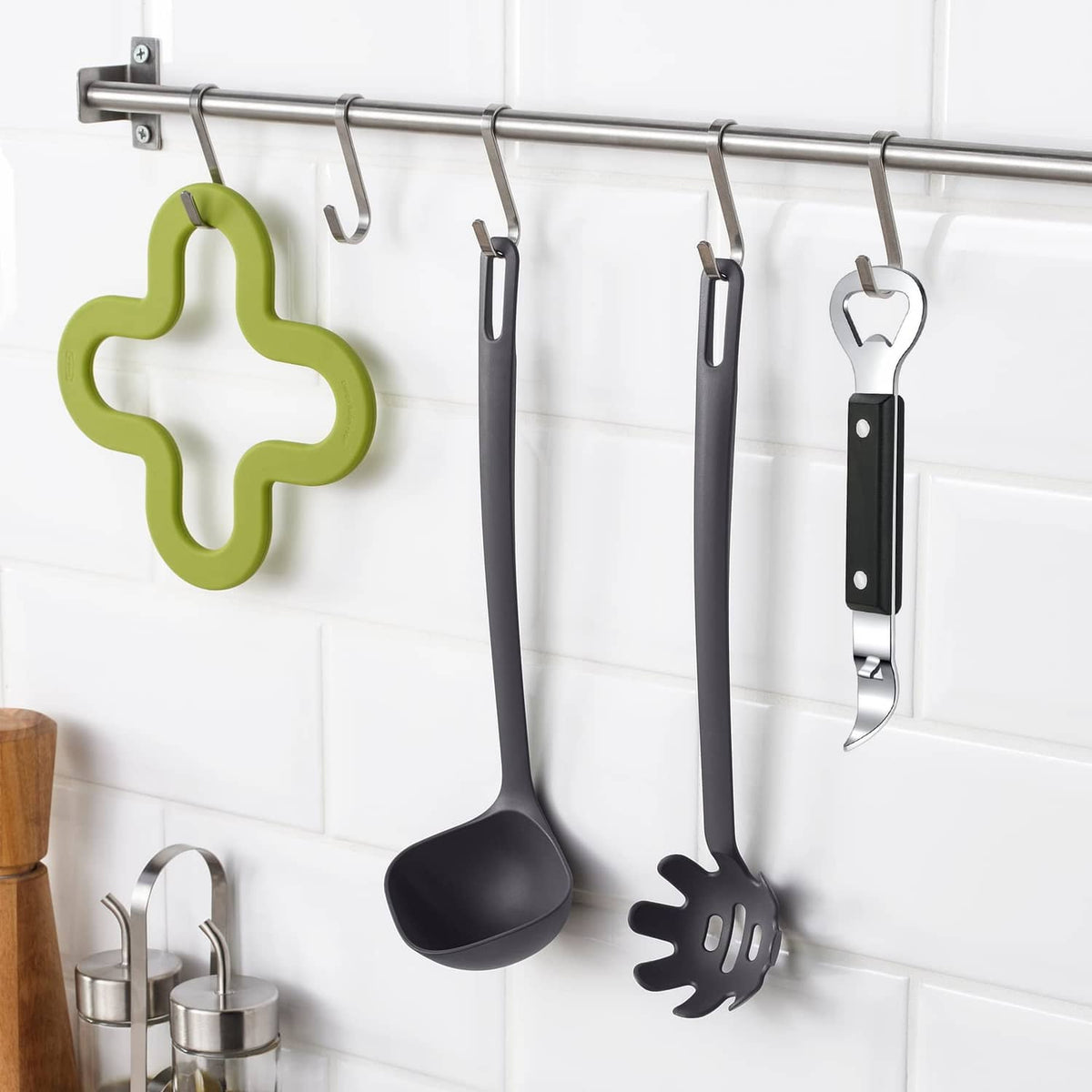 Can punch bottle opener hanging on a kitchen rack, black handle and stainless tip