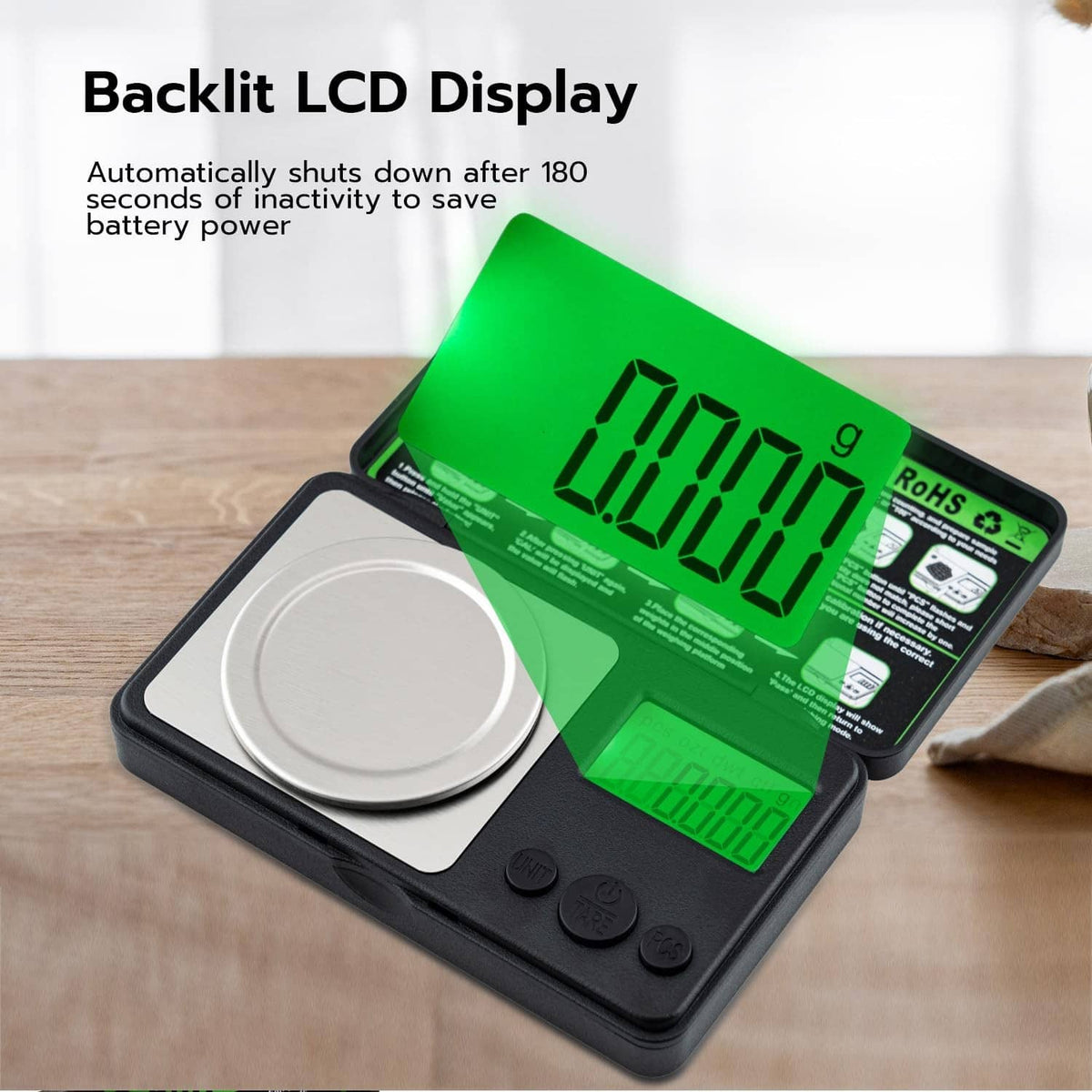Black mini digital milligram scale with backlit green LCD display and round weighing platform