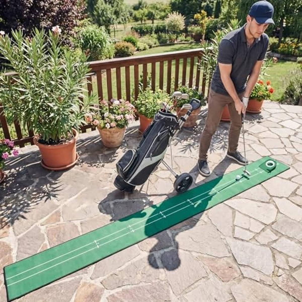 Green golf putting mat with alignment grid and cup flag on patio surface
