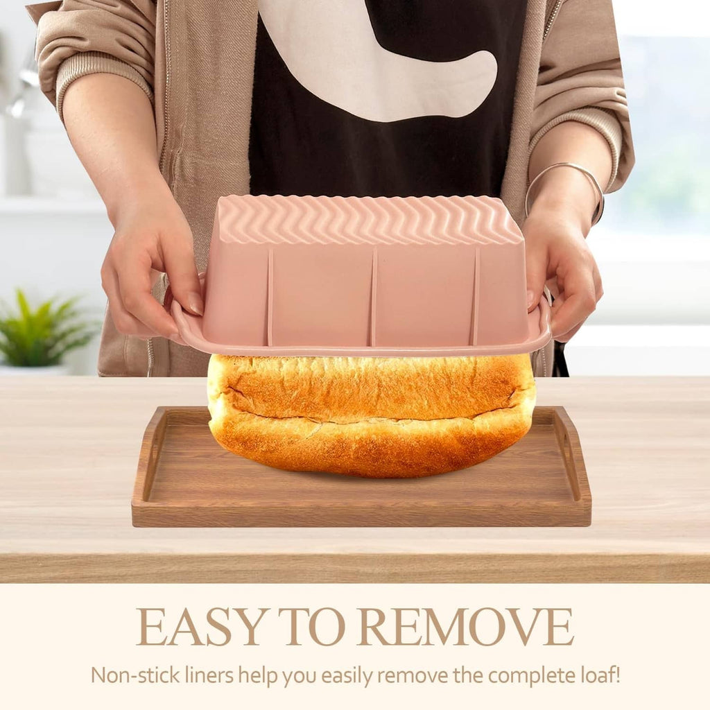 Pink silicone rectangular loaf pan being held with baked bread