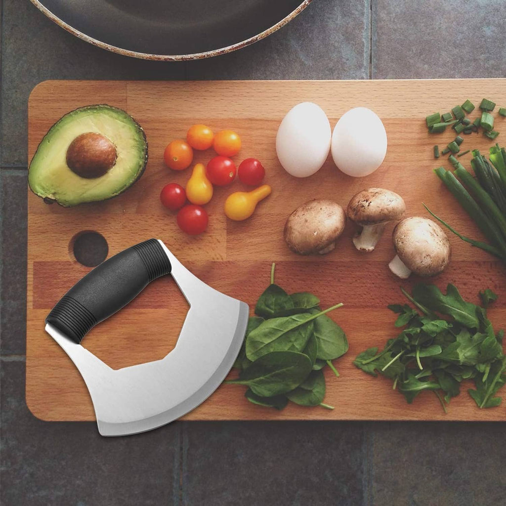 Salad chopper blade and black handle placed on a wooden cutting board with ingredients