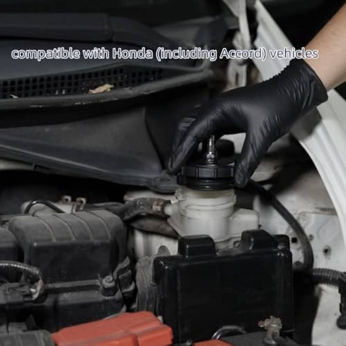 Brake bleeder adapter installed in engine bay near master cylinder, gloved hand shown