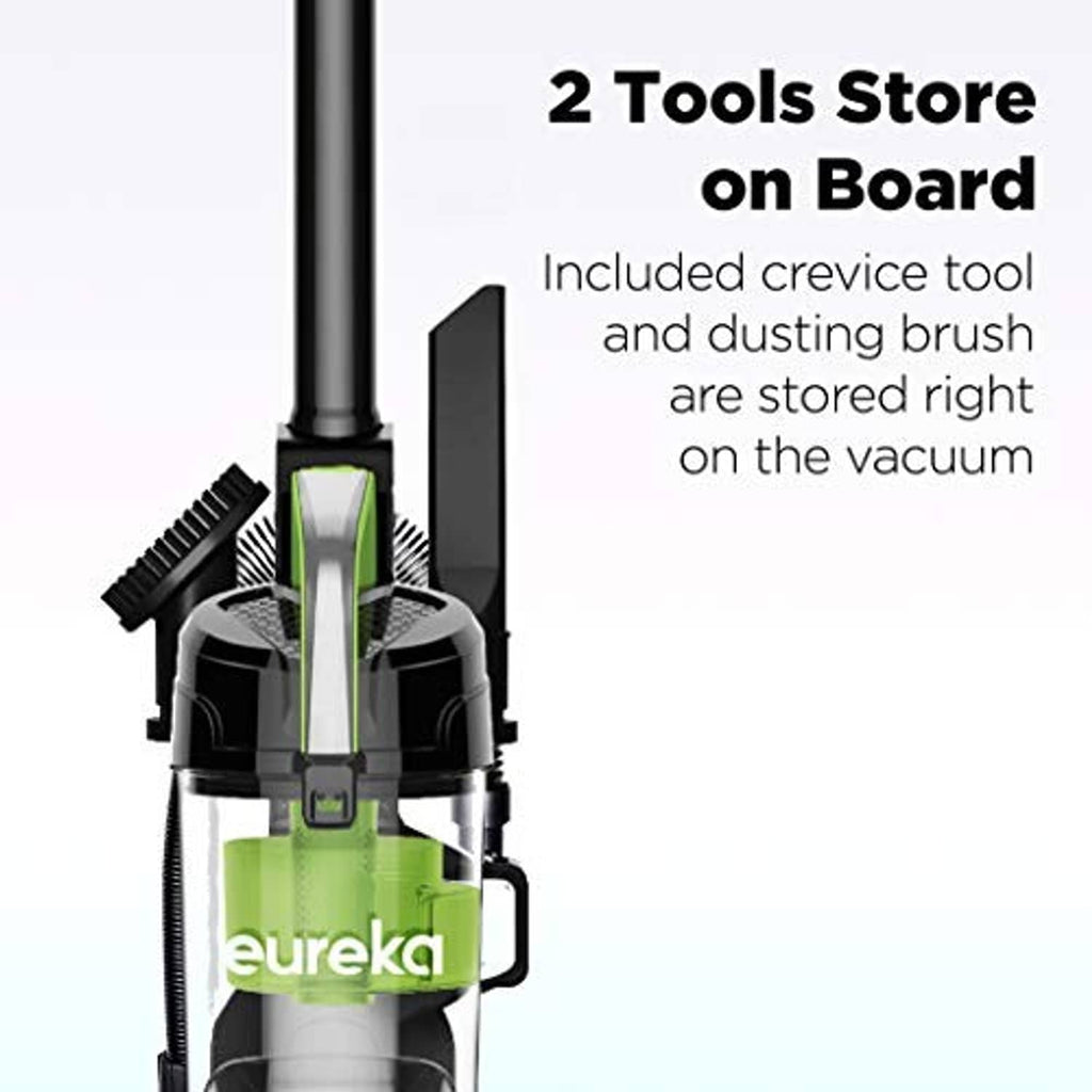 Green bagless upright vacuum showing two tools stored onboard: crevice and dusting brush