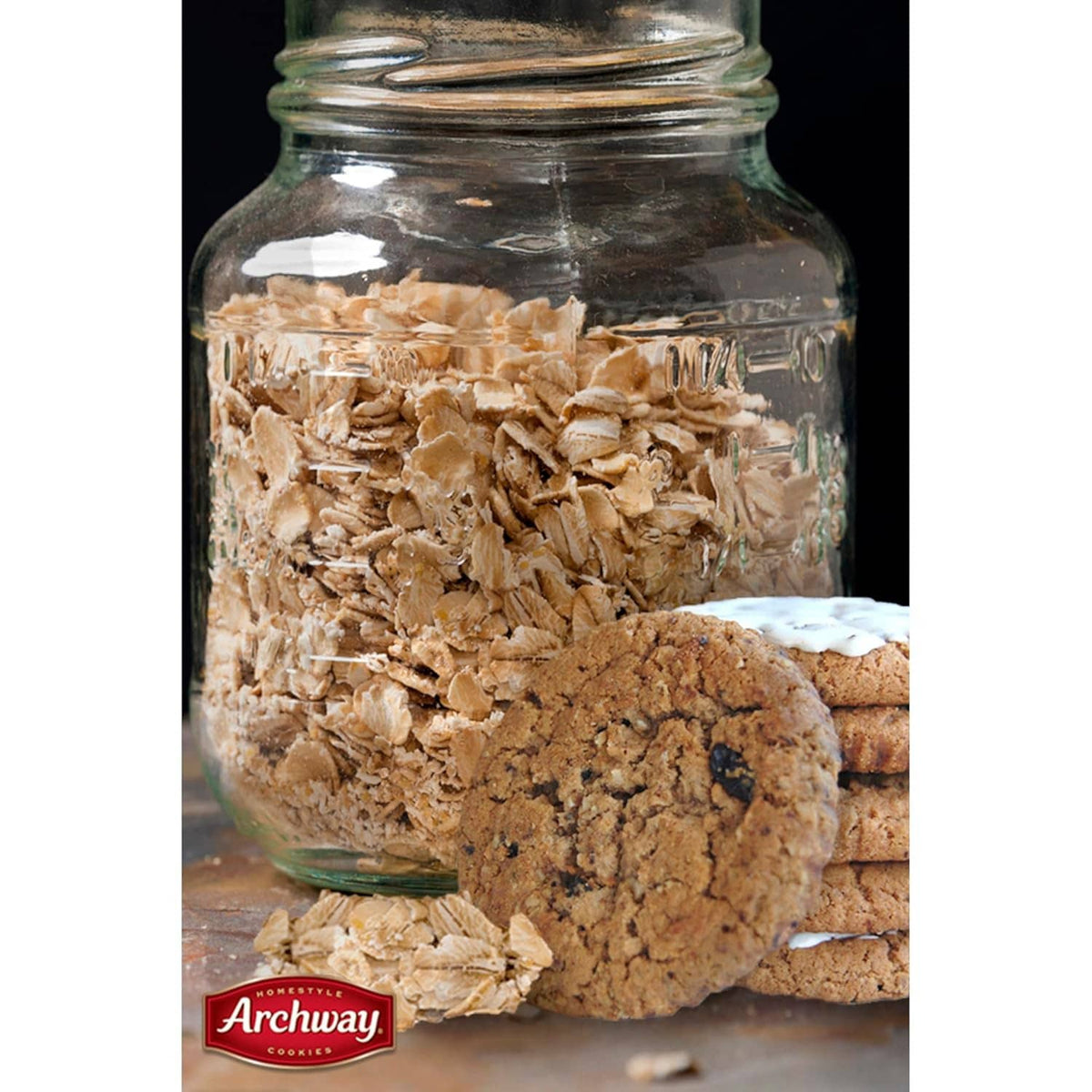 Glass jar filled with oatmeal flakes and soft oatmeal raisin cookies