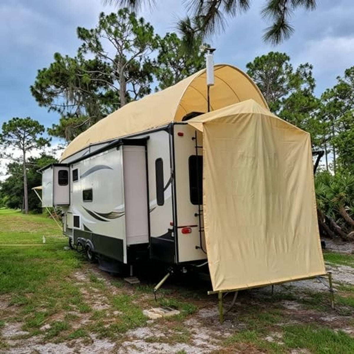 Sand sun shade cloth shelter attached to an RV doorway with support poles