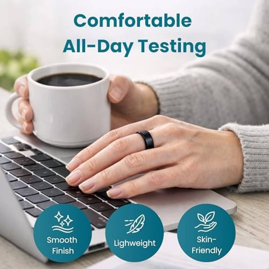 Black ring for sizing worn on hand resting near a laptop and coffee mug
